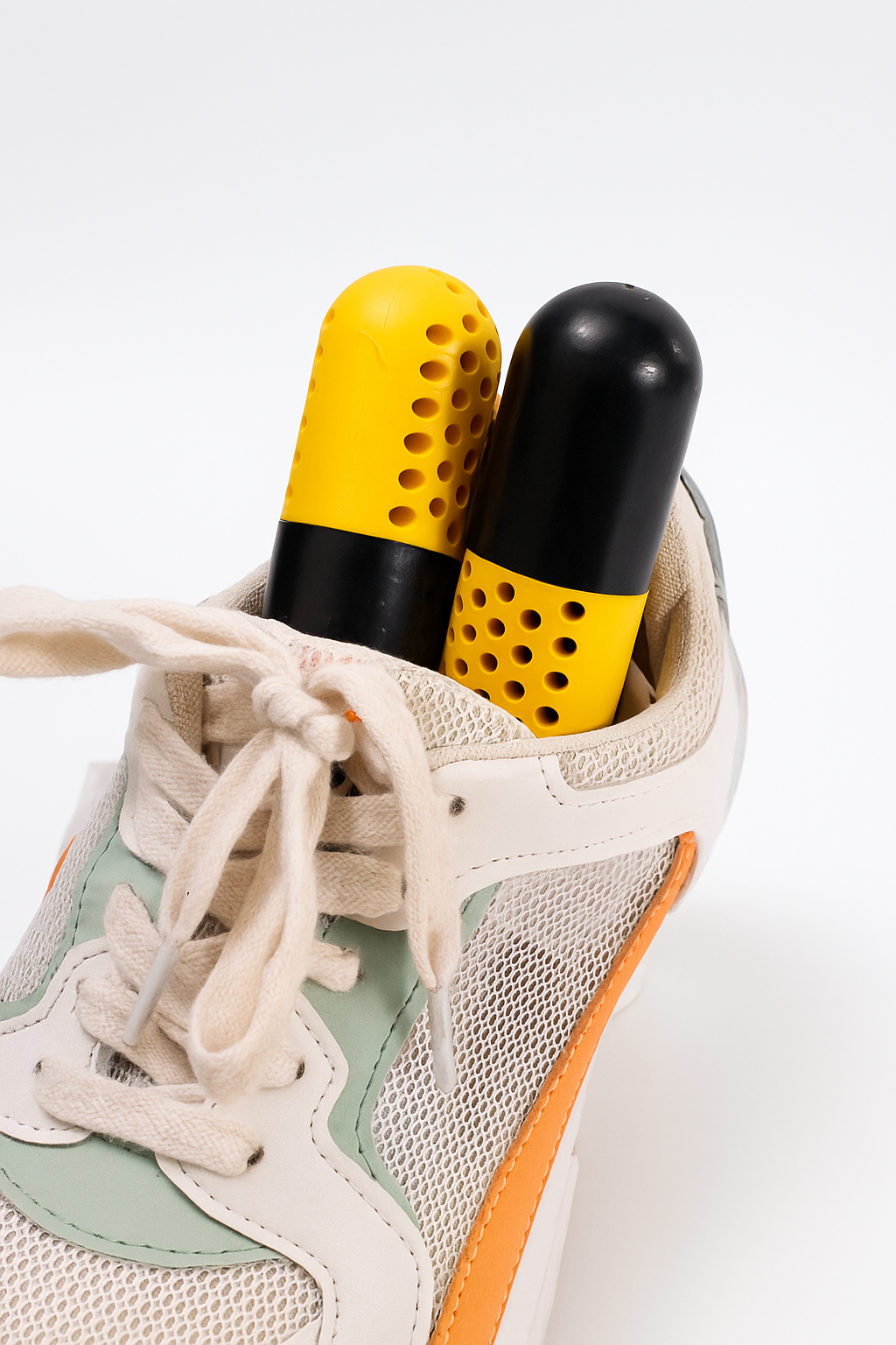 Gelb-schwarze Schuh-Deodorizer-Kapseln in einem Sportschuh zur Geruchsneutralisierung und Feuchtigkeitsaufnahme